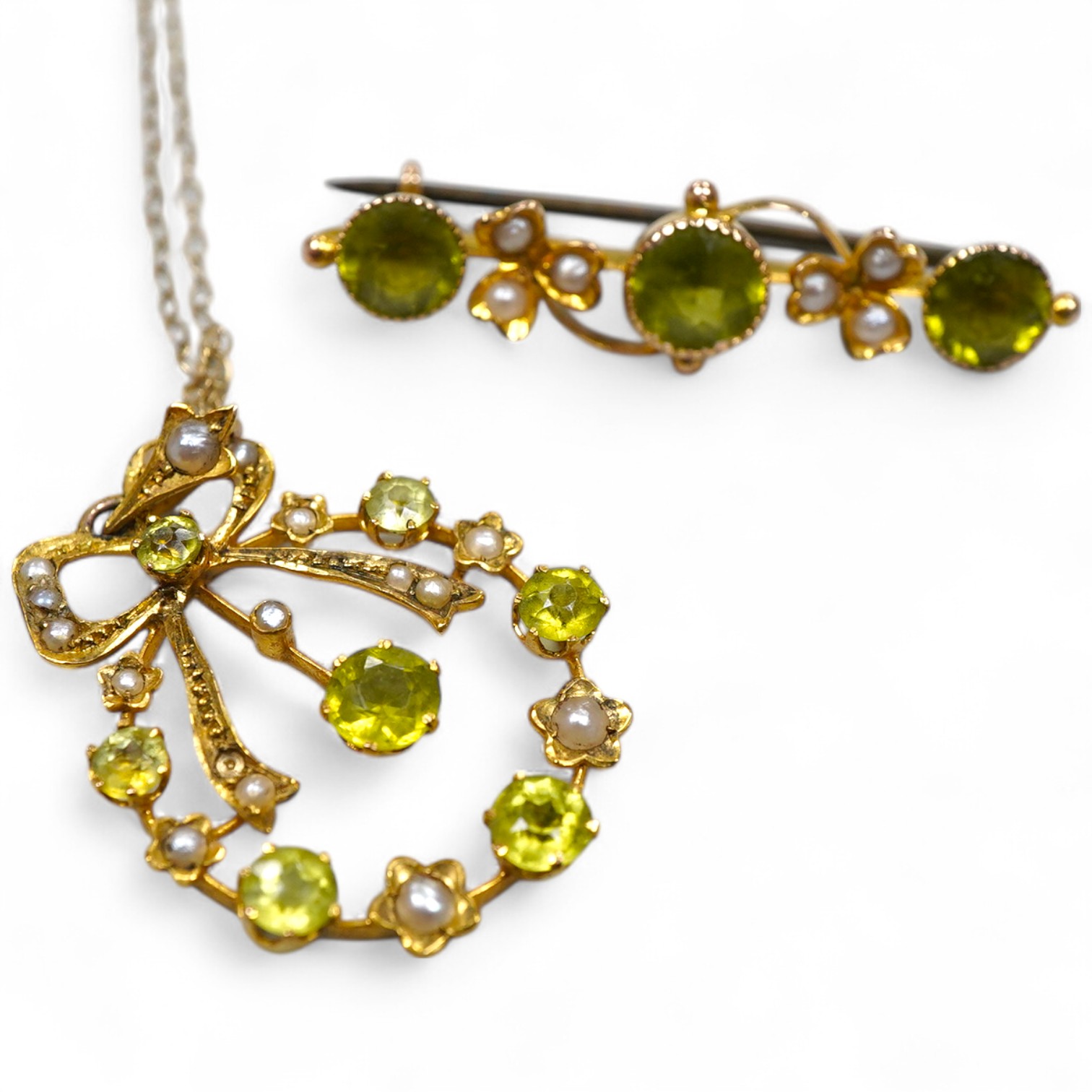 Two Edwardian peridot and seed pearl jewels, early 20th century, comprising: a bar brooch and a pendant, each of foliate design, set with circular-cut peridots and seed pearls, mounted in gold, brooch length 3.5cm, maker